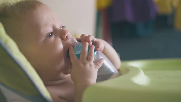 Boy with Water Bottle in Highchair and Elder Sister in Room alt