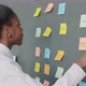 Young Creative Businesswoman Sticking Sticky Notes on Office Wall Working Alone - VideoHive Item for Sale