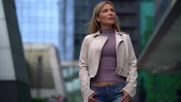 Alone Sad Blonde Woman Is Walking on City Street, Looking Around alt