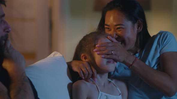 Parents Watching Movie with Daughter at Night alt