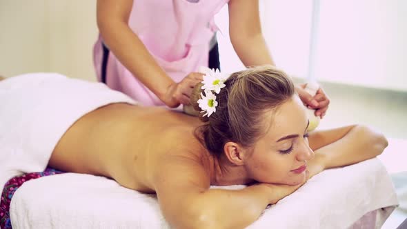 Massage Therapist Using Herbal Compress on Woman alt