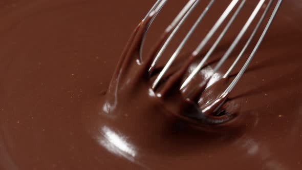 Slow Motion Mixing Stirring Premium Dark Melted Chocolate with a Whisk Process of Making Sweets alt
