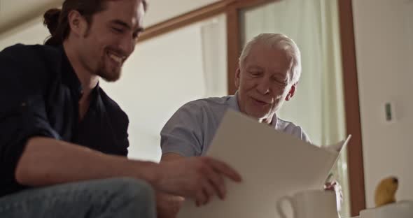 Father and Son Examining Photos Together alt