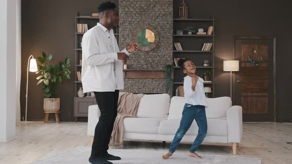 Happy Two Active African American Family Dancing in Living Room Carefree Adult Father Man and Cute alt