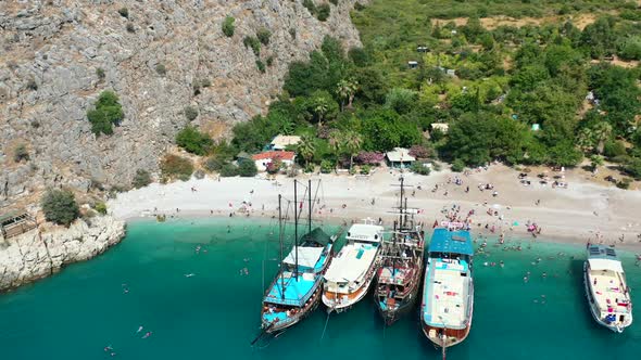 aerial drone circling pirate cruise ships anchored on the beach at Butterfly Valley in Fethiye Turke alt