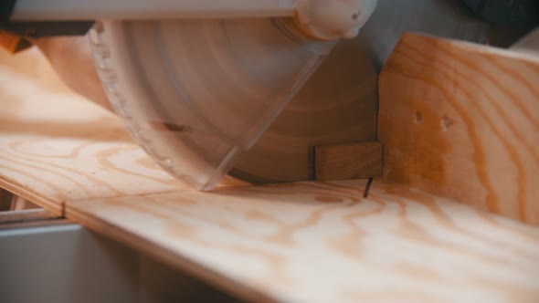 Carpentry - a Woodworker Cutting the Wooden Detail with a Circular Saw - Cutting Off a Little Piece alt