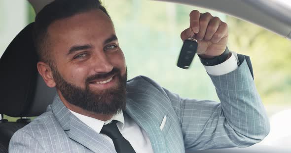 Confident Businessman Smiling To Camera and Showing Key of His New Car, Close Up alt