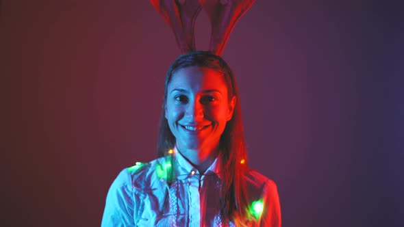 Portrait of Beautiful Smiling Woman with Christmas Lights Around Her Neck alt