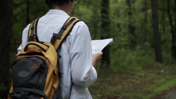 Young  Woman  Traveler  With  Backpack  Walks,  Looks  At  Map,  European  Tourist  On  Hike alt