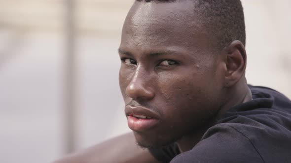young serious black american man turning and looking at camera- outdoor alt