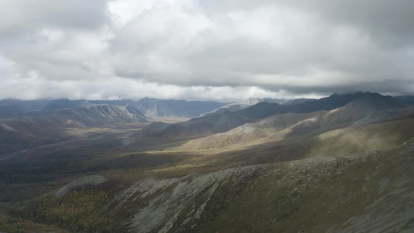 Aerial natural view of mountains covered by green grass on cloudy sky background alt
