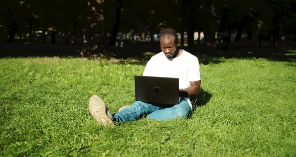 African-american Male on Grass with Laptop