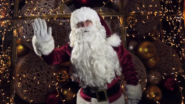 merry santa claus waving his hands and recording a virtual greeting on christmas eve alt
