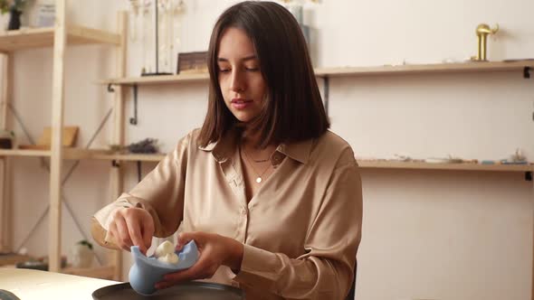 Attractive Young Woman Artisan Taking Out Beautiful White Piece of Author Candle of Silicone Mold alt