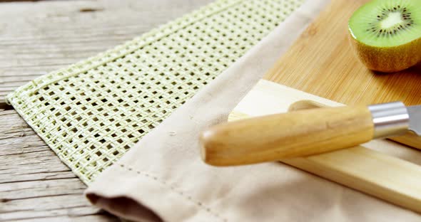 Kiwi and knife on chopping board alt