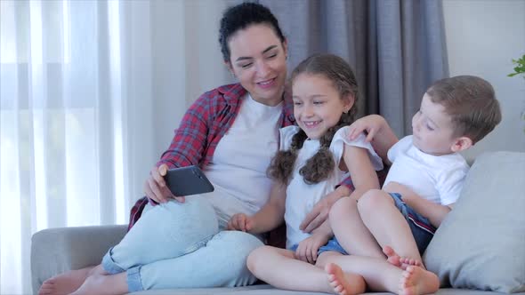 Happy Family,mom and Cute Little Children Watch the Phone,mom Plays with Children at Home,relaxing alt