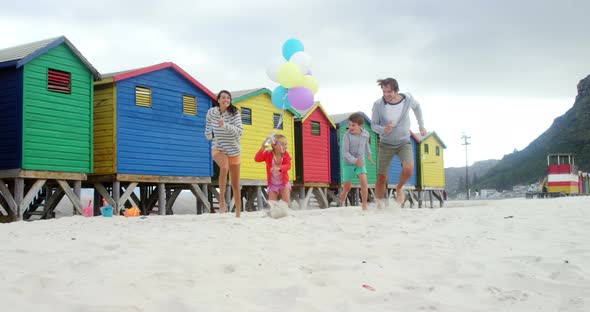 Happy family running at beach alt