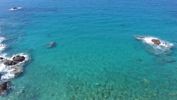 Aerial Clear Reef and Rocky Untouched Coastline of Bright Turquoise Sea alt