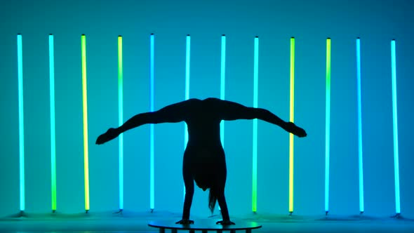 A Woman Standing on Her Hands Does a Split Stretches Her Legs Up Bends Them Sits in a Fold Pose alt