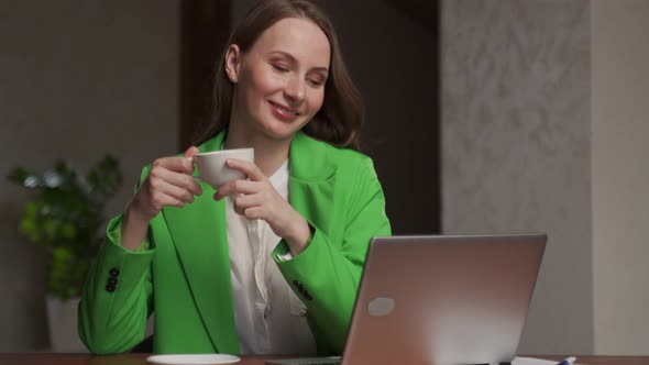 Young Secretary Enjoys Cup of Coffee Working on Computer alt