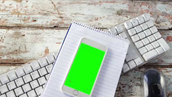 Coffee cup, mobile phone, notepad, keyboard, mouse on wooden plank alt