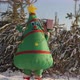 A Man in a Christmas Tree Doll Costume is Merrily Dancing with a Gift in His Hand - VideoHive Item for Sale