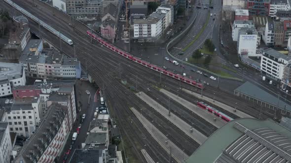 AERIAL: Over Cologne Railway Train System with Train Driving on Cloudy Day  alt