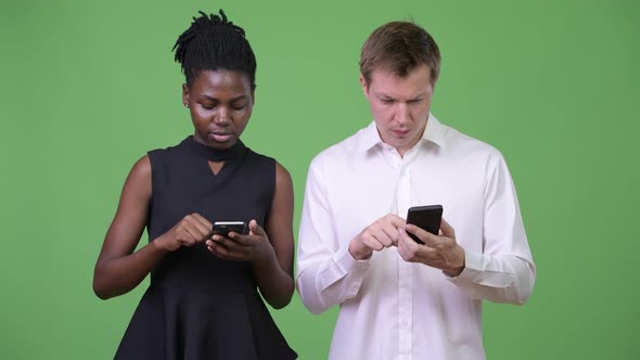 Two Young Multiethnic Business Couple Using Phone Together