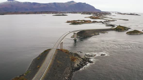 Car Driving Down On Storseisundet Bridge At Atlanterhavsveien In Norway. - aerial alt