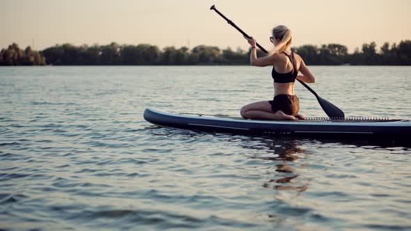 Woman Meditating Pose Sup Board On Vacation.Cross-Legged No Stress Leisure Surfing Boat Fitness. alt