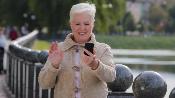 Happy Senior Woman of Retirement Age Making Video Call Looking at Smartphone Camera alt