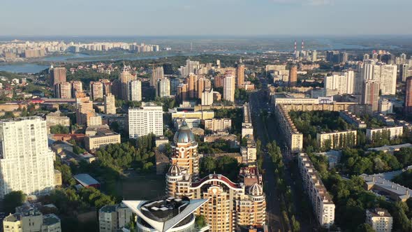 Aerial drone video of downtown apartment buildings, Dnipro river, and cars on the highway in Pechers alt