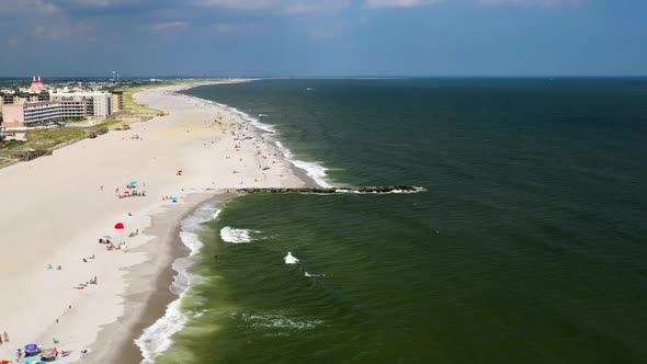 drone aerial dolly shot forward over the beach in Oceanside, New York, then rise up to view horizon alt