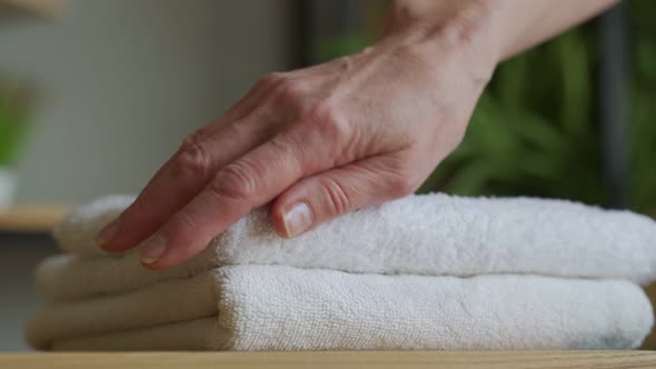 Old Woman Touches a Fresh White Towel alt