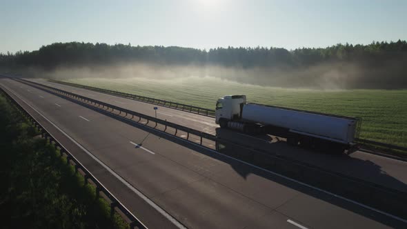 Tanker truck in motion on the highway in the early morning at dawn. Fuel delivery, transportation. alt