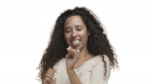 Closeup of Happy Latino Girl with Long Curly Hairstyle Wearing Casual Tshirt Dancing and Smiling alt