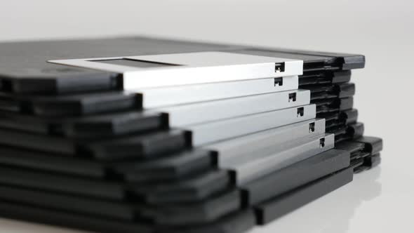 Classic magnetic floppy disc  storage media on white 4K 2160p 30fps UHD tilting footage - Stack of o alt