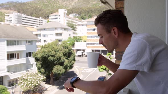 Young man drinking coffee in the balcony at home 4k