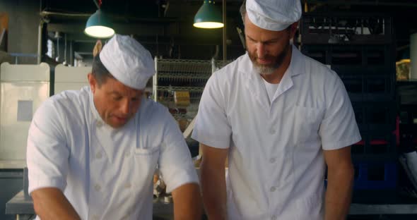 Head chefs training chef on pizza dough  alt