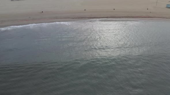AERIAL: Towards Venice Beach Skatepark From Ocean with Water,waves in Morning, Cloudy Los Angeles alt