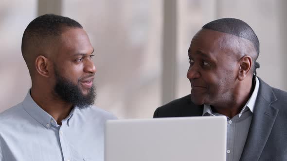 Serious Young African Businessman Speaking to Black Male Mature Boss Partner Investor Explaining alt