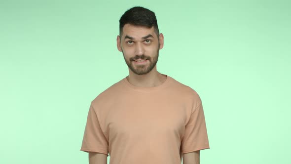 Handsome Caucasian Guy with Beard Standing in Green Tshirt and Saying Yes with Confidence Nod in