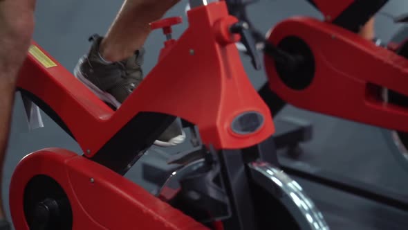 Feet of athletes on spinning bikes alt