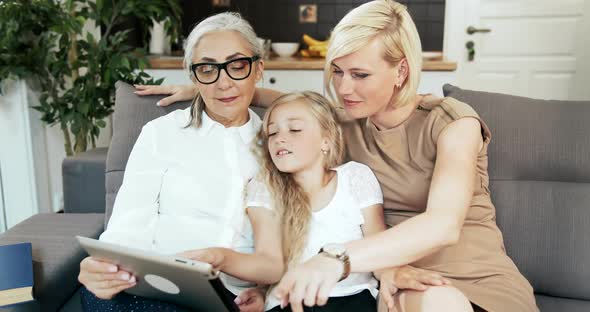 Family with Tablet on Sofa