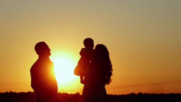 Unrecognizable Silhouette of Family at Sunset Mom Tosses the Baby Family Values alt