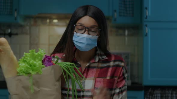 Pretty Young African American Woman Wearing Eye Glasses Taking Off Face Protective Mask Looking at alt