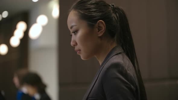 Asian Woman Working at Front Desk in Hotel alt
