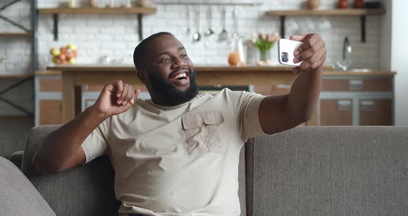 Young Handsome African American Man Holding Smartphone in Outstretched Arm Making Conference Over alt