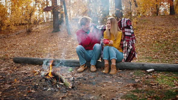 Young Man Smiling Covering Girlfriend with Plaid alt