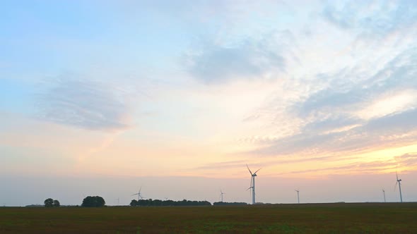 Wind Turbine in an Offshore Wind Farm in the Green Field Against Low Sun on Sunrise the Closeup